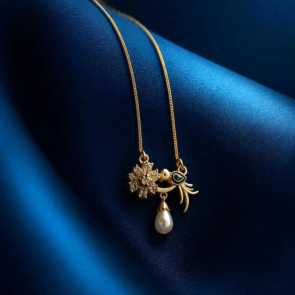 Gold necklace with a pendant featuring a pearl on a blue fabric background