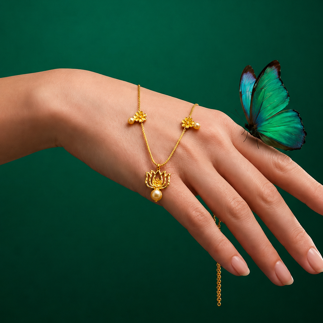 Gold jewelry on a hand with a green butterfly against a green background