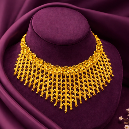 Gold necklace on a purple velvet stand with a soft focus background