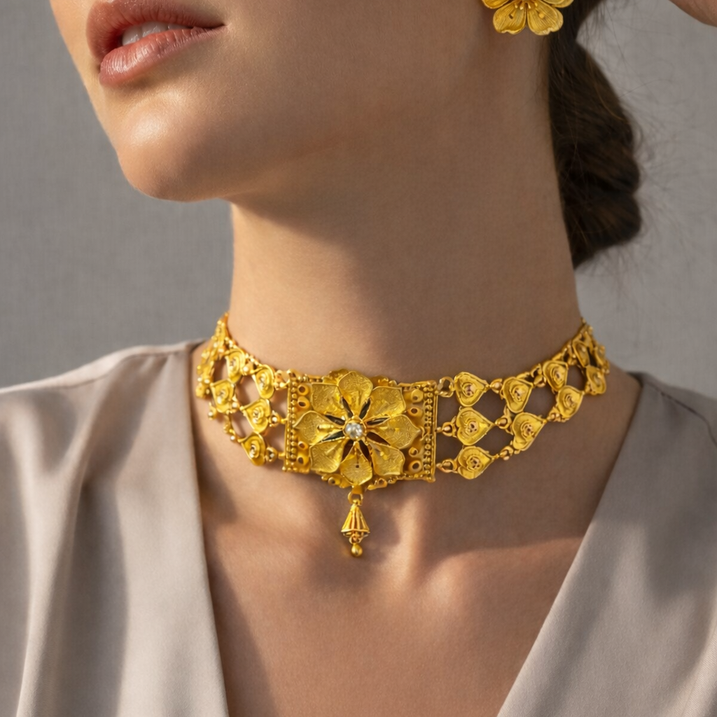 Woman wearing a gold necklace and earrings with a neutral background