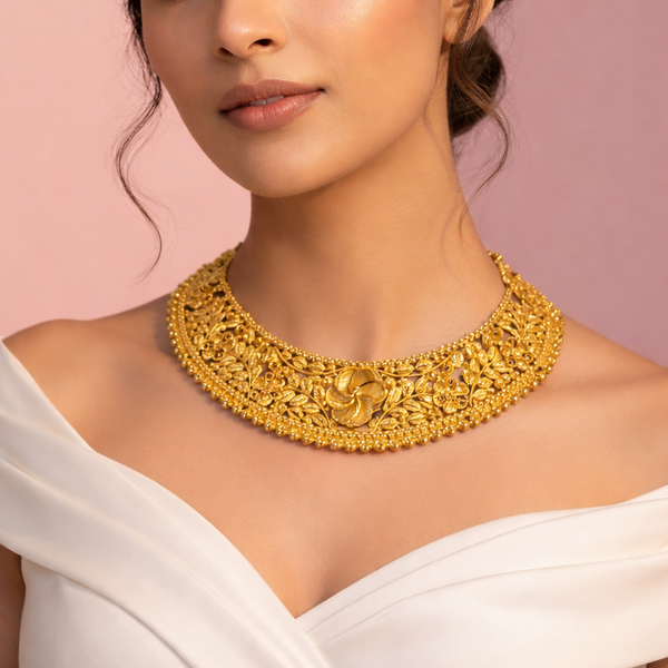 Woman wearing a gold necklace against a pink background