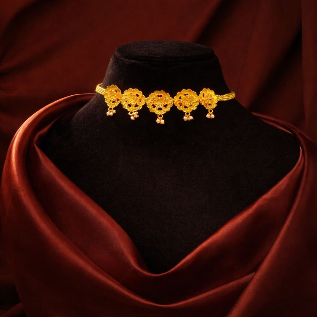 Gold necklace on a black velvet stand with a red fabric background